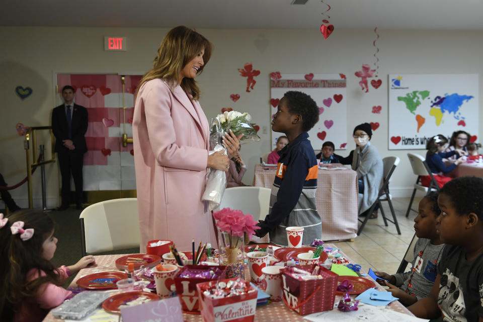 First lady Melania Trump is presented with a bouquet of flowers from Amani, 13, of Mombasa, Kenya, during her visit to the National Institutes of Health to see children at the Children's Inn in Bethesda, Md., Thursday, Feb. 14, 2019, and celebrate Valentine's Day. Amani also presented the first lady with a necklace that matched his bracelet. (AP Photo/Susan Walsh)