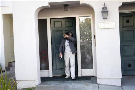 A woman identified as a supporter of California state Senator Leland Yee covers her face as she exits the senator's home in San Francisco, California March 27, 2014. REUTERS/Stephen Lam