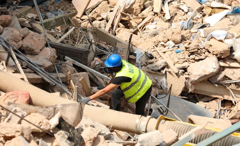 A volunteer digs through the rubble of buildings which collapsed due to the explosion at the port area, after signs of life were detected, in Gemmayze, Beirut