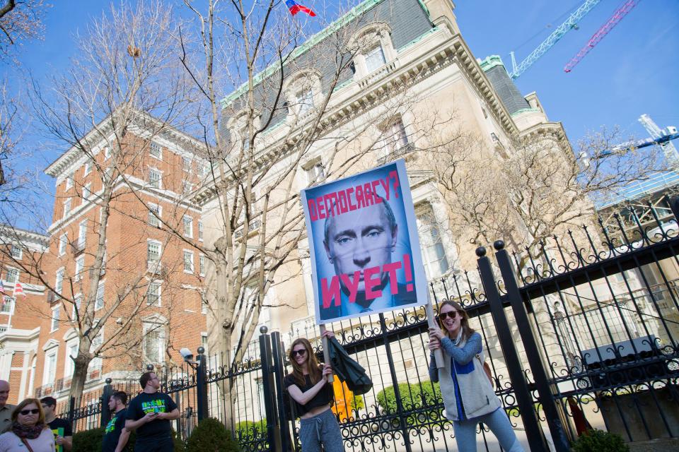 Protesters hold up a sign showing Russian President Vladimir Putin in front of the Russian ambassador's residence in Washington in 2017.