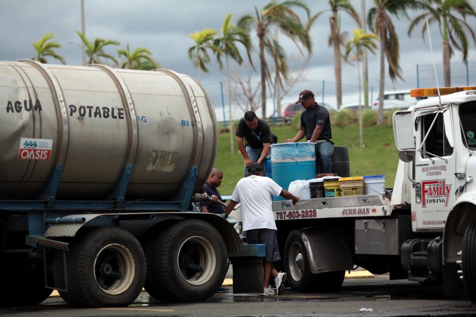 Local residents fill cans of water in Carolina, Puerto Rico, on Saturday. (Photo: Alvin Baez / Reuters)