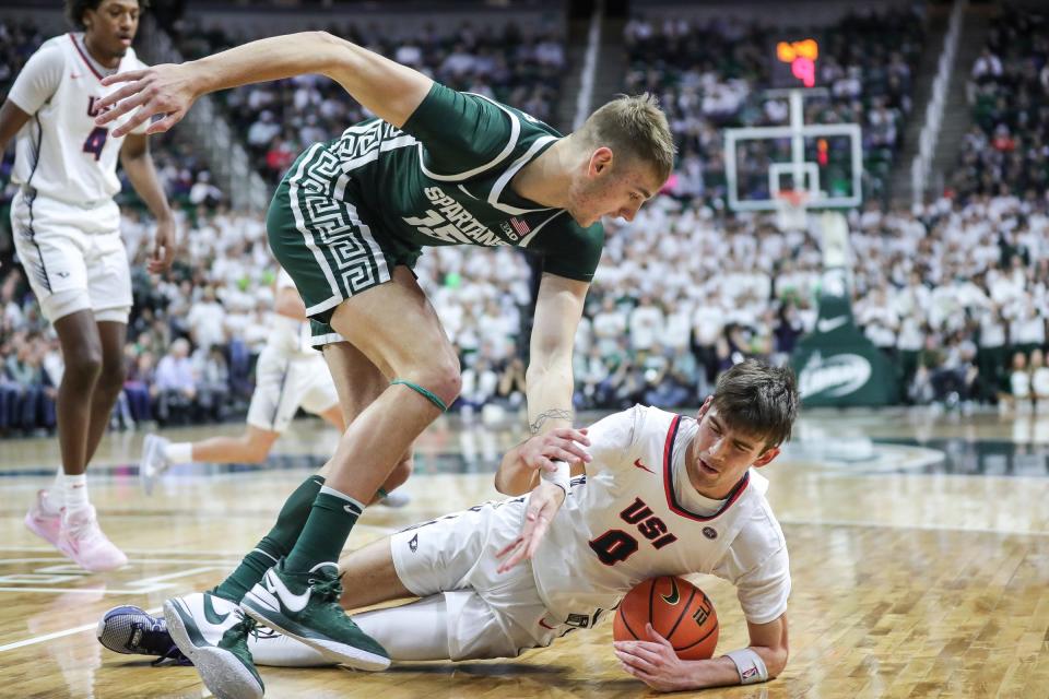 Michigan State center Carson Cooper (15) battles for the ball with Southern Indiana guard Ryan Hall (0) during the first half at Breslin Center in East Lansing on Thursday, Nov. 9, 2023.