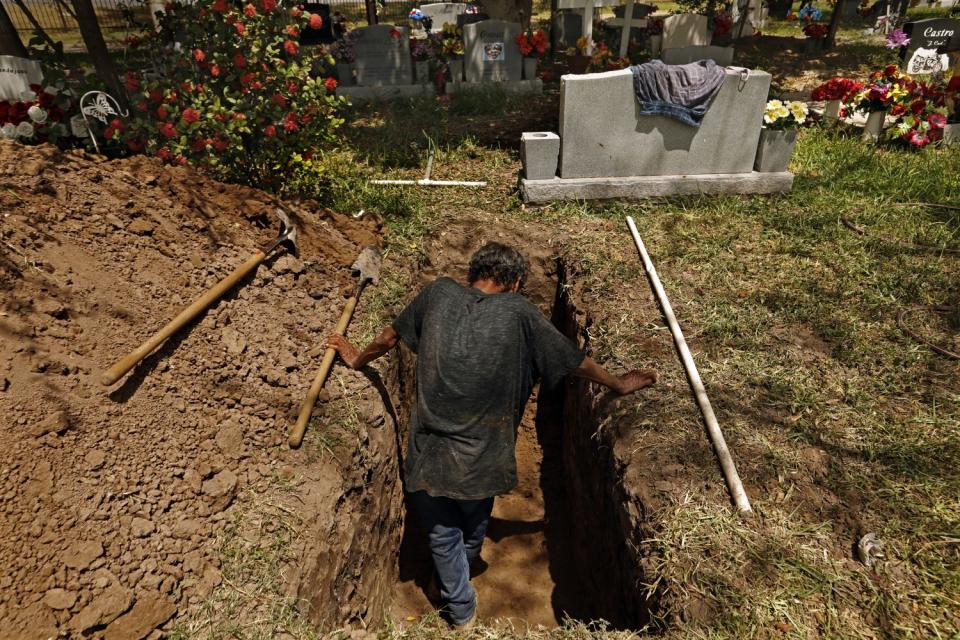 Jesus Torres, 75, digs a grave at La Piedad Cemetery in McAllen, Texas.