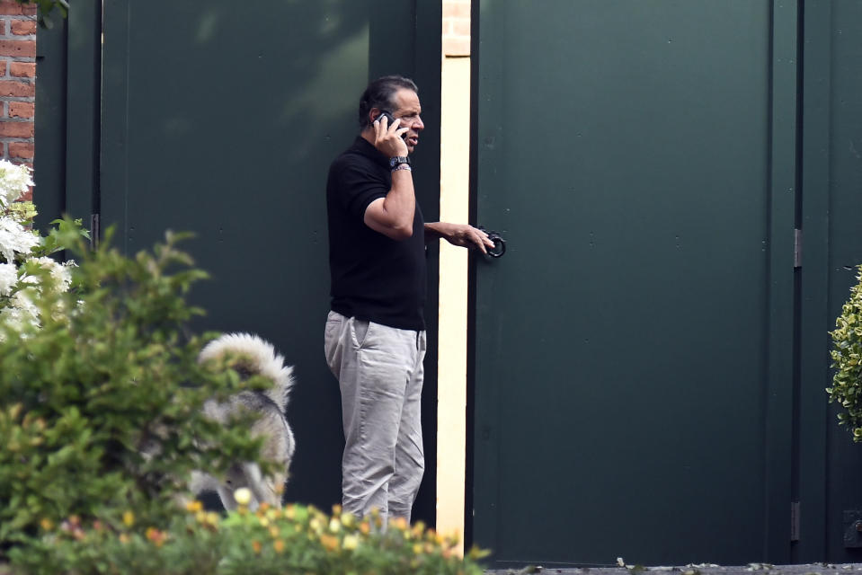 Gov. Andrew Cuomo talks on the phone while walking with his dog Captain at the New York state Executive Mansion, Saturday, Aug. 7, 2021, in Albany, N.Y. An investigation found that Cuomo sexually harassed multiple women in and out of state government. (AP Photo/Hans Pennink)