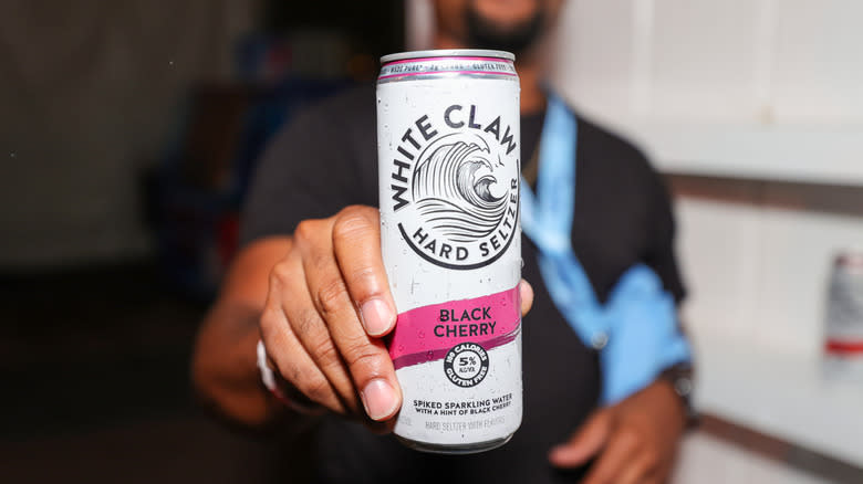 Hand holding a can of White Claw hard seltzer