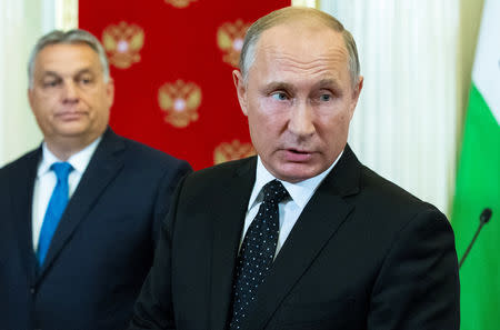 Russian President Vladimir Putin accompanied by Hungarian Prime Minister Viktor Orban answers reporters questions after their talks at the Kremlin in Moscow, Russia September 18, 2018. Alexander Zemlianichenko/Pool via REUTERS