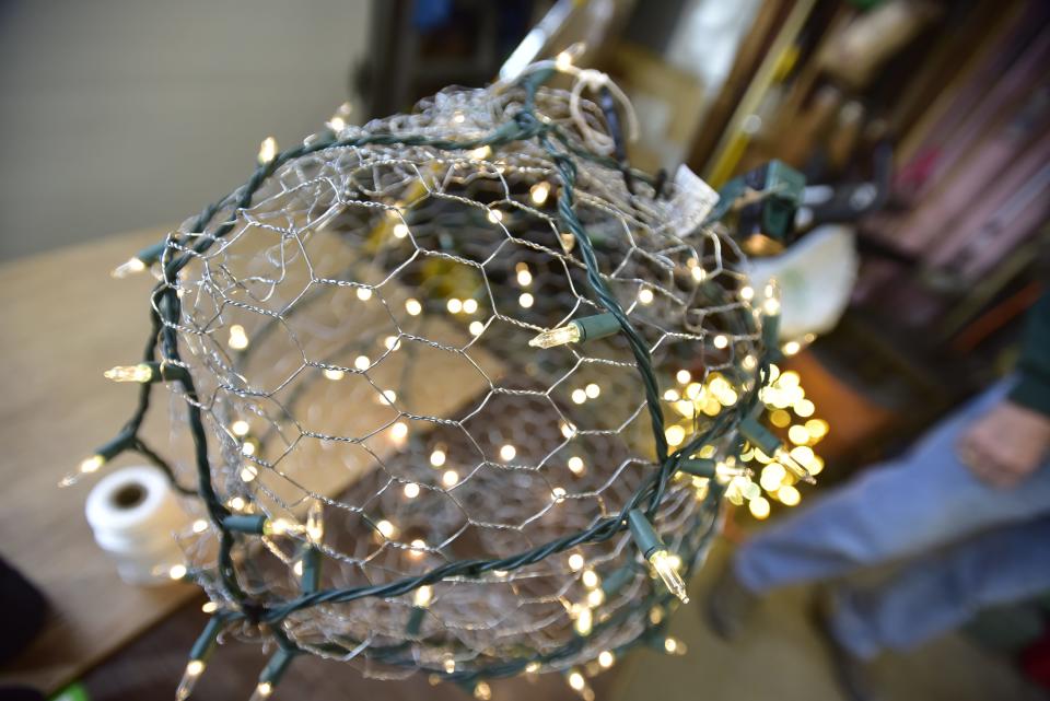 The decorated chicken wire Christmas balls made Sherman Woods Association president Fred Kemp in the northside neighborhood of Port Huron on Thursday, Nov. 17, 2022. The colorful decorations are strung up in trees by neighbors every year to attract passerbys to leave a donation in a Salvation Army red kettle.