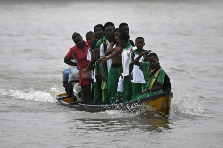 Des étudiants traversent la rivière Atrato dans un bateau à moteur en bois pour aller étudier dans la municipalité de Quibdo, département de Choco, Colombie, le 30 août 2024. (Raul ARBOLEDA)