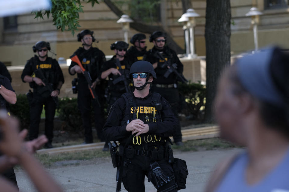 Members of the Sheriff's Department in riot gear stand by as demonstrators gather outside Akron City Hall to protest the killing of Jayland Walker.
