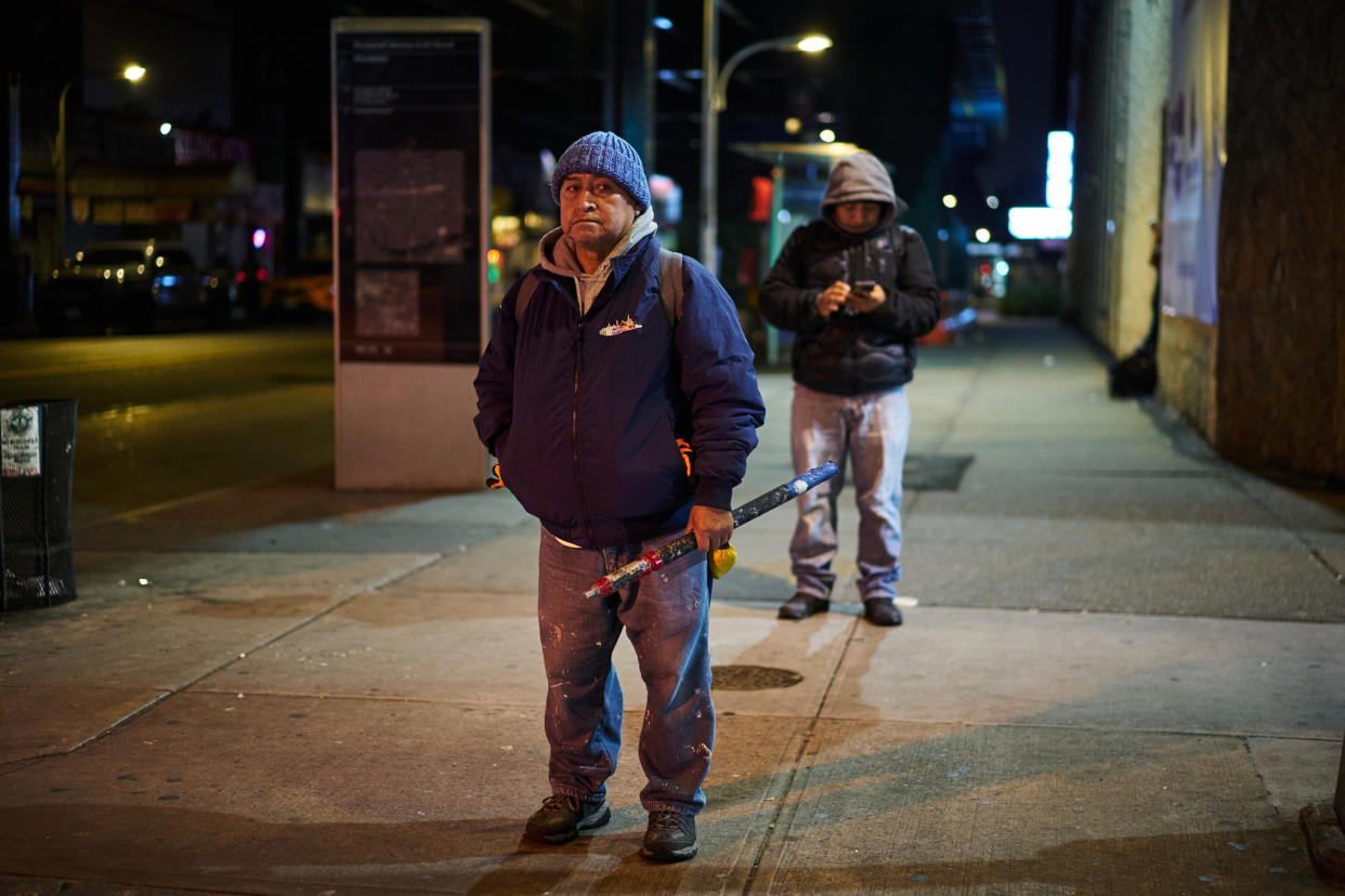 Francisco Palacios, de 70 años, que llegó a la ciudad de Nueva York en 1986 desde Ecuador, con la esperanza de algún día ahorrar lo suficiente para regresar a su país y jubilarse, espera antes del amanecer en una esquina donde a veces pide trabajo, en el barrio de Jackson Heights de Queens, el 8 de diciembre de 2023. (Bing Guan/The New York Times).