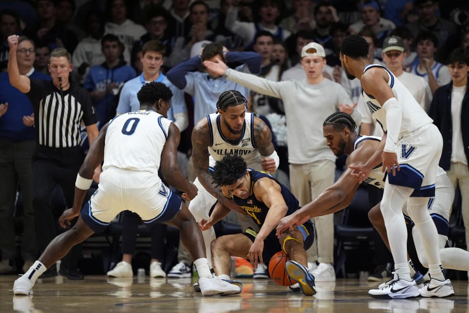 Marquette's Stevie Mitchell, center, tries to hang onto the ball against Villanova's TJ Bamba, from left, Justin Moore, Eric Dixon and Mark Armstrong during the second half of an NCAA college basketball game, Tuesday, Jan. 30, 2024, in Villanova, Pa. (AP Photo/Matt Slocum)