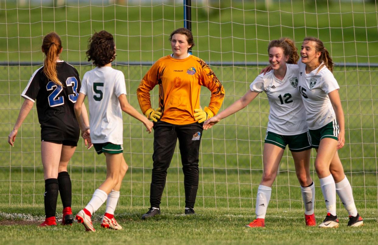 Alleman's Audrey Erickson and Meredith Maynard celebrate a score against Rockford Christians Tess Combs on Friday, May 20, 2022, at Hinckley-Big Rock High School in Hinckley.