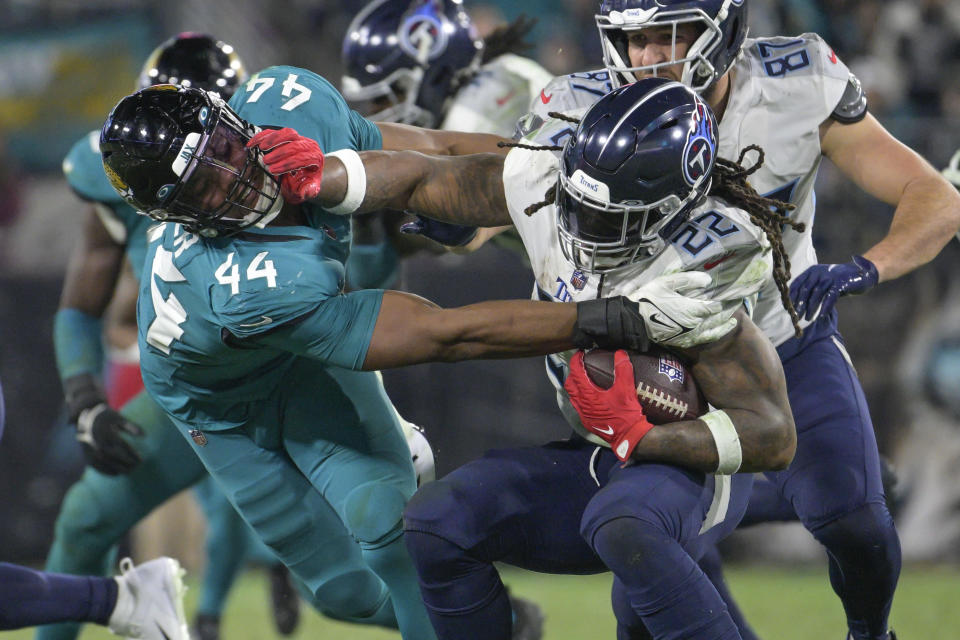 Tennessee Titans running back Derrick Henry is stopped for a loss by Jacksonville Jaguars linebacker Travon Walker (44) in the second half of an NFL football game, Saturday, Jan. 7, 2023, in Jacksonville, Fla. (AP Photo/Phelan M. Ebenhack)