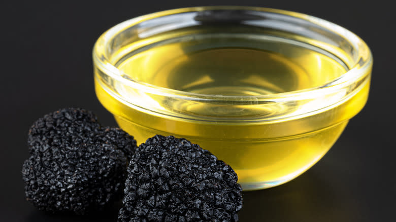 Bowl of truffle oil with black truffles