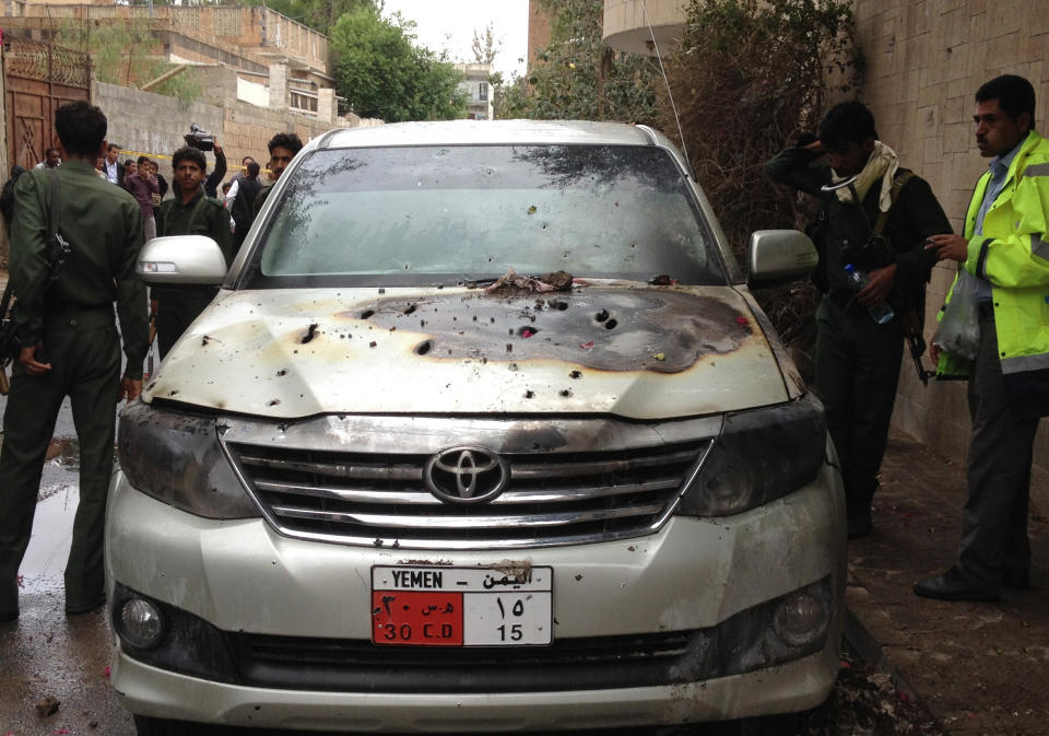 Yemeni policemen inspect a damaged car after gunmen opened fire on French security guards on a street in Sanaa, Yemen, Monday, May 5, 2014. Unknown gunmen in Yemen's capital opened fire on three French security guards working with the European Union mission on Monday, killing at least one and wounding another, interior ministry officials said. (AP Photo/Ahmed Yahya)