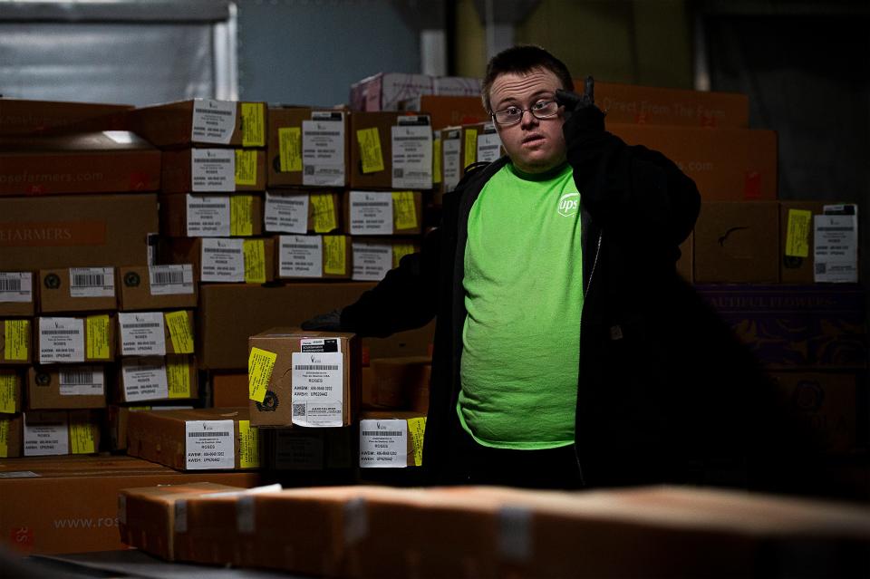 Preston Haggerman adjusts his glasses while waiting on the conveyor belt to start moving during a recent shift at the UPS Worldport facility in Louisville, Ky. Haggerman was hired on through the UPS Transitional Learning Center for people with physical or intellectual disabilities and is now working hard and earning his own money. Feb. 7, 2023