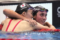 Yui Ohashi, of Japan, left, is embraced by Emma Weyant, of United States, after winning the final of the women's 400-meter Individual medley at the 2020 Summer Olympics, Sunday, July 25, 2021, in Tokyo, Japan. (AP Photo/Matthias Schrader)