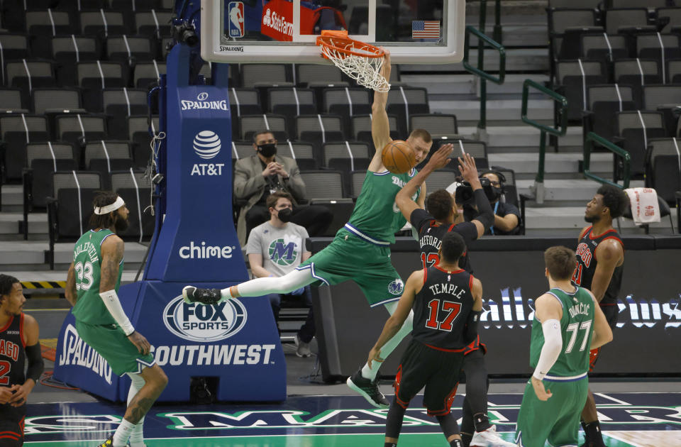 Dallas Mavericks forward Kristaps Porzingis (6) scores over Chicago Bulls center Daniel Gafford (12) during the first half of an NBA basketball game, Sunday, Jan. 17, 2021, in Dallas. (AP Photo/Ron Jenkins)