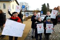 Demonstrators hold pro-Tesla posters during an action to support plans by U.S. electric vehicle pioneer Tesla to build its first European factory and design center in Gruenheide near Berlin