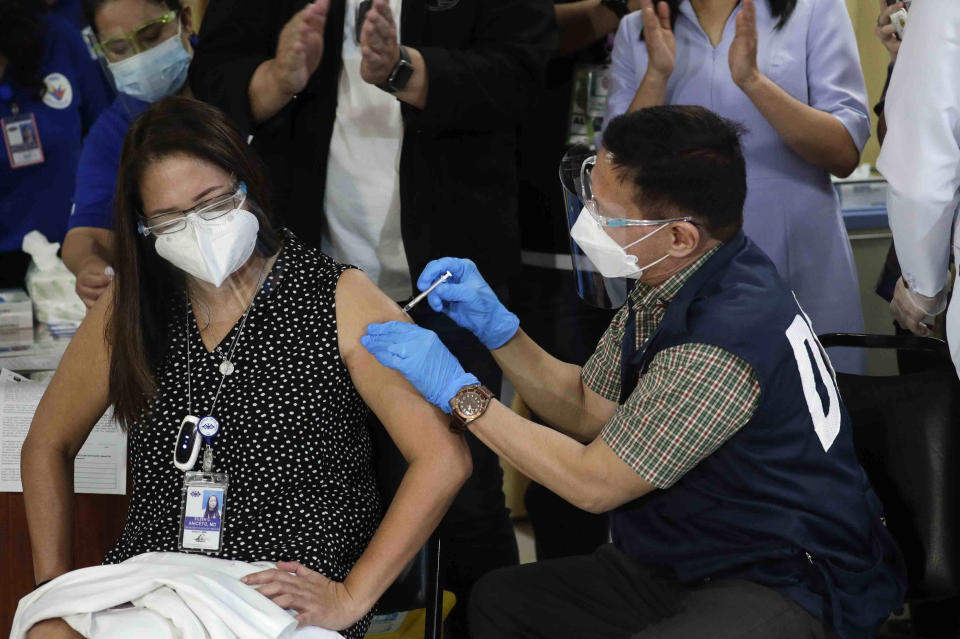Health Secretary Francisco Duque III, right, injects China's Sinovac vaccine on Filipino doctor Eileen Aniceto during the first batch of vaccination at the Lung Center of the Philippines in Quezon city, Philippines on Monday, March 1, 2021. The Philippines launched a vaccination campaign Monday to contain one of Southeast Asia's worst coronavirus outbreaks but faces supply problems and public resistance, which it hopes to ease by inoculating top officials. (AP Photo/Aaron Favila)