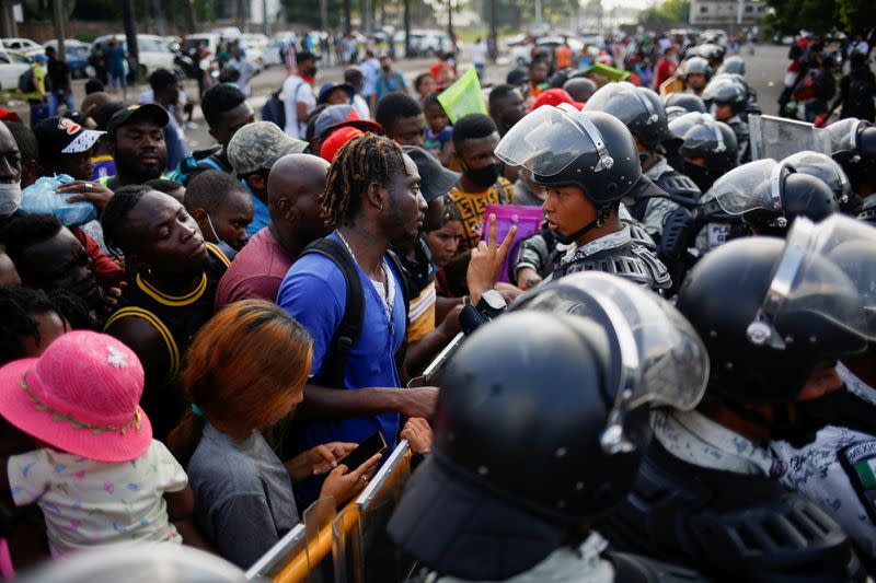 Migrants queue to get on buses after accepting an offer from the Mexican government to obtain humanitarian visas, in Tapachula