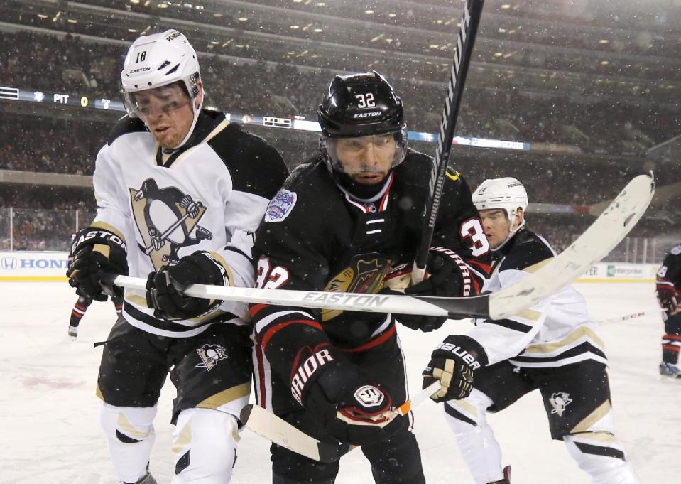 Pittsburgh Penguins left wing James Neal (18) and Chicago Blackhawks defenseman Michal Rozsival (32) look for the puck in the corner during the first period of an NHL Stadium Series hockey game at Soldier Field on Saturday, March 1, 2014, in Chicago. (AP Photo/Charles Rex Arbogast)