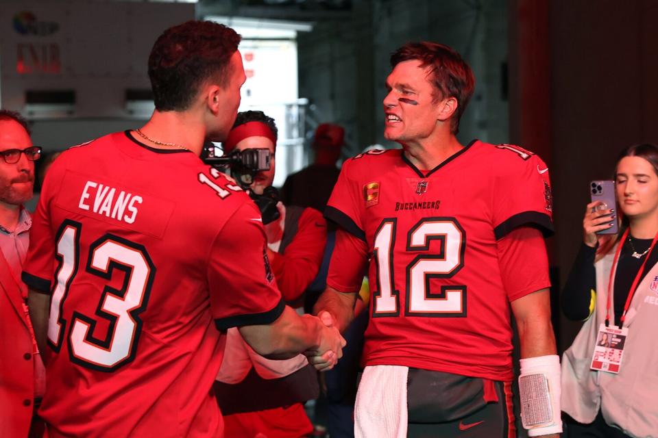 Major League Baseball player Aaron Judge talks with Tampa Bay Buccaneers quarterback Tom Brady (12) before an NFL football game against the New Orleans Saints in Tampa, Fla