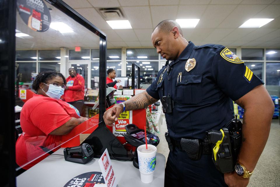 Tallahassee Police Department Sgt. Damon Miller jokes with the cashier at a local convenience store while purchasing some midnight snacks during his overnight patrol Tuesday, March 15, 2022.