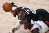 Houston Rockets' Robert Covington, top, and Oklahoma City Thunder's Dennis Schroder, bottom, scramble on the floor for a loose ball during the second half of an NBA first-round playoff basketball game in Lake Buena Vista, Fla., Wednesday, Sept. 2, 2020. (AP Photo/Mark J. Terrill)