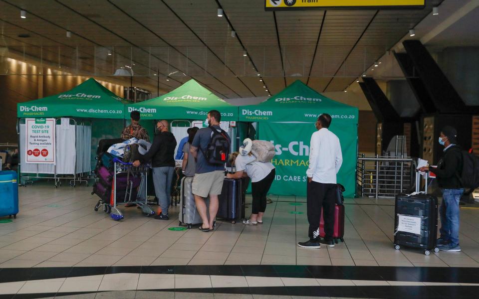 Travellers queue at an area for PCR Covid-19 tests at OR Tambo International Airport in Johannesburg on November 27 - Phill Magakoe/AFP via Getty Images