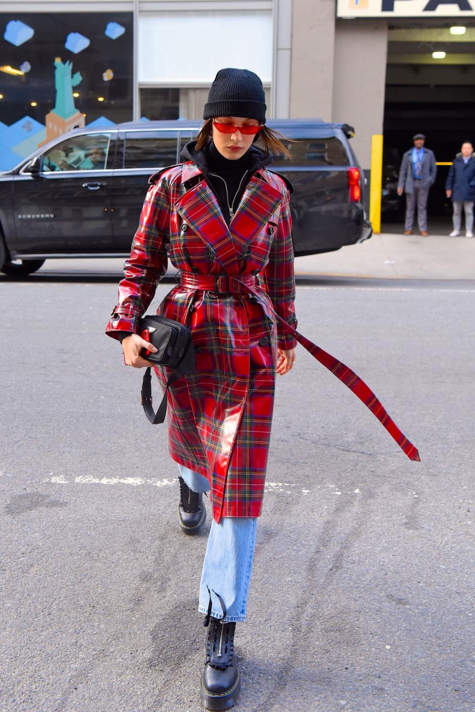 Who: Bella Hadid<br> What: Burberry, Poppy Lissiman sunglasses, Prada bag, Dr. Martens shoes<br> Where: On the street, New York City<br> When: January 31, 2018