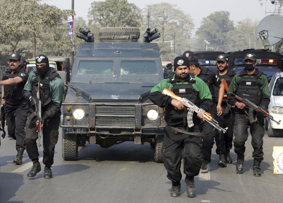 FILE-- In this Feb. 7, 2018, file photo, Pakistani police commandos escort a police van carrying Mohammad Imran, who is accused of the brutal killings of eight children in the eastern city of Kasur, as it arrives at an anti-terrorist court, in Lahore, Pakistan. The serial killer of eight children was executed at a Pakistani prison Wednesday morning, Oct. 17, 2018, after the country's top court rejected a request for his public hanging, officials said. (AP Photo/K.M. Chaudary, File)