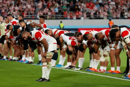 Japan captain Michael Leitch leads his team in bowing to the Tokyo crowd after losing to South Africa