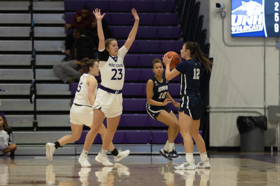 Holy Cross sophomore Grace Munt defends against New Hampshire's Adara Groman, right.