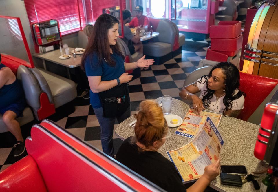 Ashlee Eisenstein, 49, of Phoenix, Arizona (left) takes an order from Jennifer Rivera, 35, of New York (right)  at the 5 & Diner in Phoenix, Arizona.