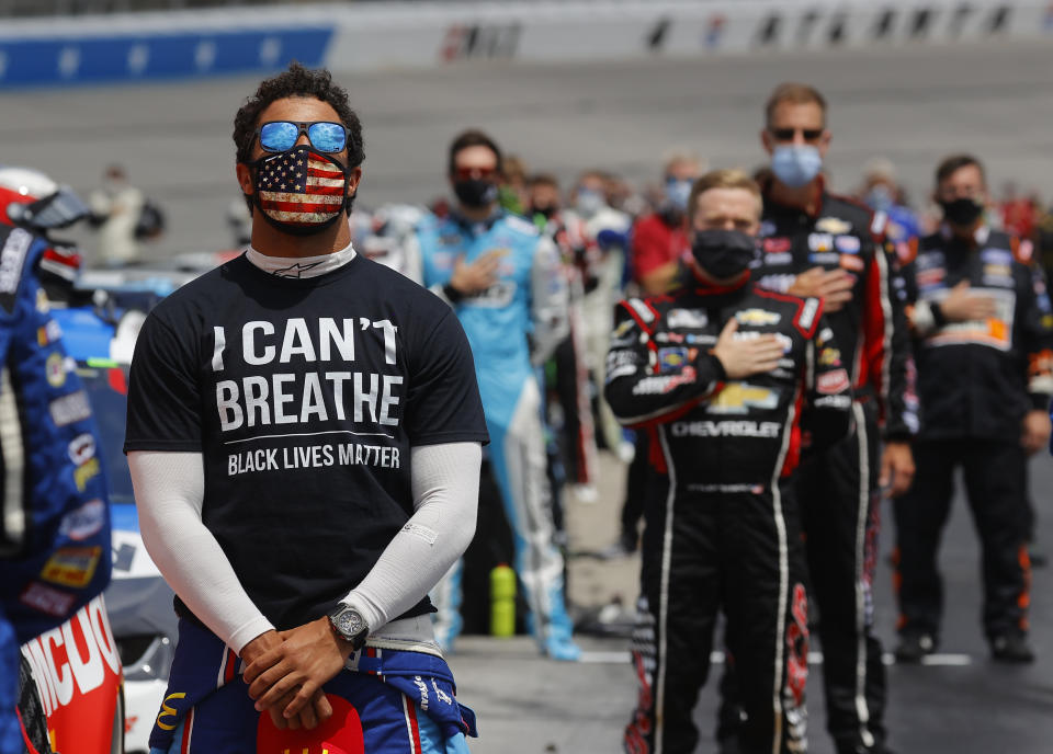 Bubba Wallace, driver of the #43 McDonald's Chevrolet, wears an "I Can't Breathe — Black Lives Matter" T-shirt under his fire suit while standing during the national anthem prior to the NASCAR Cup Series Folds of Honor QuikTrip 500 at Atlanta Motor Speedway on June 07, 2020, in Hampton, Georgia.