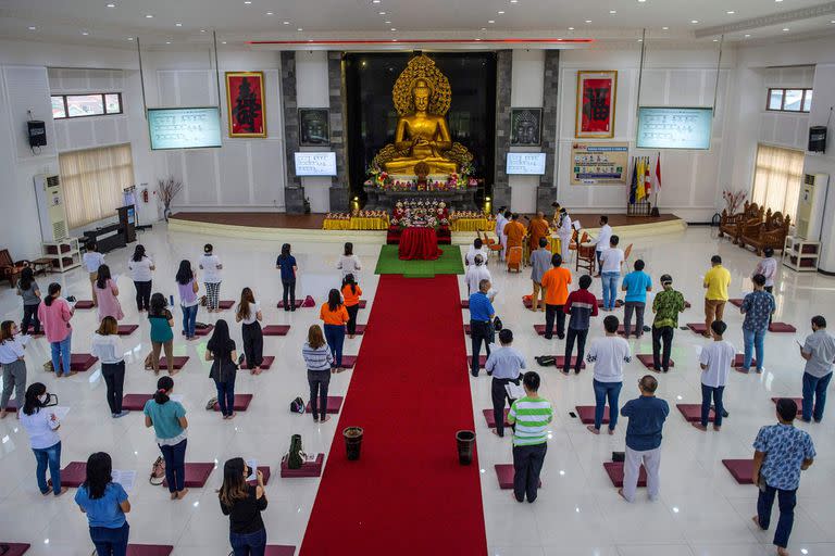 Devotos rezan junto a una estatua de Buda para conmemorar el Día de Vesak, en la ciudad de Surabaya, Java