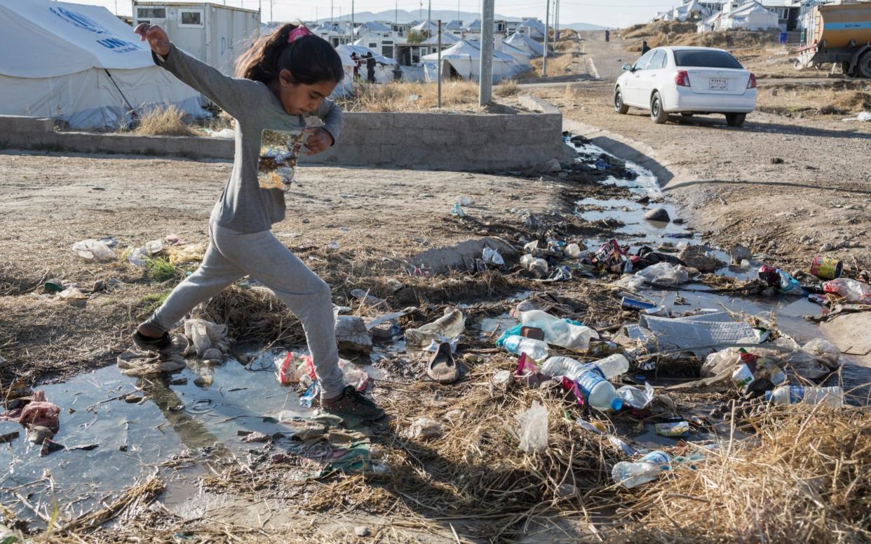 A girl crosses an open drain in Bardarash refugee camp - Sam Tarling