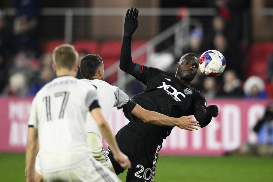 D.C. United forward Christian Benteke (20) goes for the ball against Toronto FC defender Sigurd Rosted (17) and defender Matt Hedges, center, during the second half of an MLS soccer match, Saturday, Feb. 25, 2023, in Washington. (AP Photo/Nick Wass)