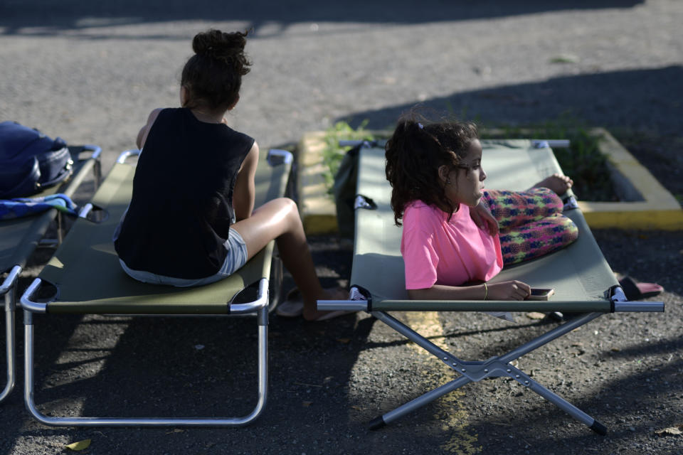 Neighbors rest outside a shelter afraid of aftershocks, after an earthquake in Guanica, Puerto Rico, Tuesday, Jan. 7, 2020. A 6.4-magnitude earthquake struck Puerto Rico before dawn on Tuesday, killing one man, injuring others and collapsing buildings in the southern part of the island. (AP Photo/Carlos Giusti)