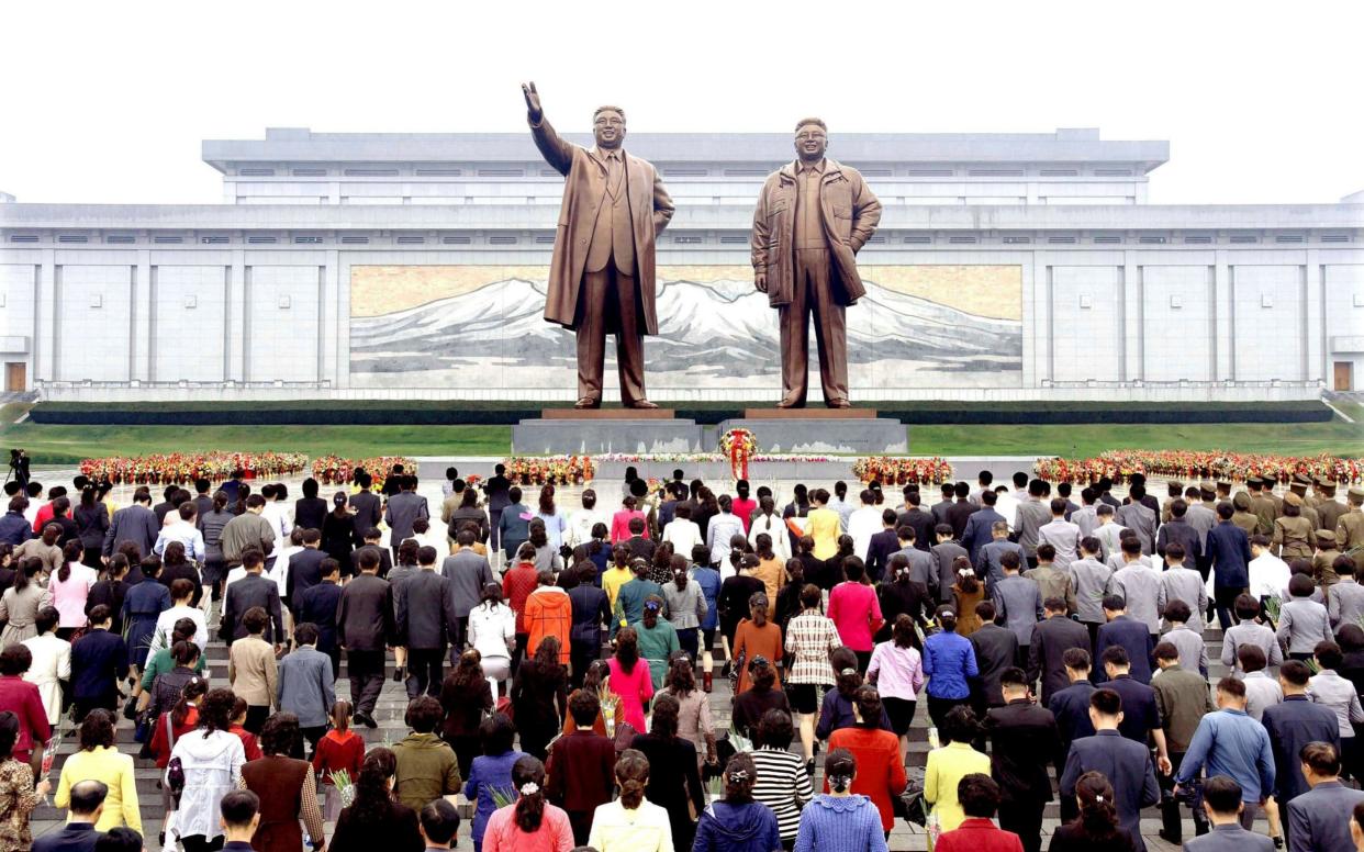 Floral tributes are paid to the statues of North Korea founder Kim Il Sung and late leader Kim Jong Il  - REUTERS