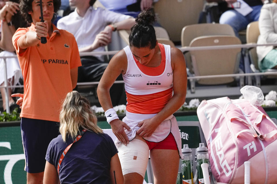 Italy's Martina Trevisan receives medical assistance for the second time in her semifinal match against Coco Gauff of the U.S. at the French Open tennis tournament in Roland Garros stadium in Paris, France, Thursday, June 2, 2022. (AP Photo/Michel Euler)