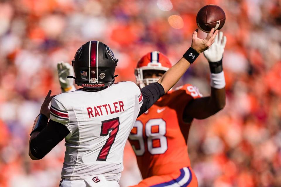 South Carolina quarterback Spencer Rattler (7) tries to pass the ball over Clemson defensive end Myles Murphy (98) in the first half of an NCAA college football game on Saturday, Nov. 26, 2022, in Clemson, S.C.