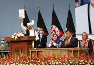 Afghan President Ashraf Ghani holds up the resolution on the last day of an Afghan Loya Jirga or traditional council, in Kabul, Afghanistan, Sunday, Aug. 9, 2020. The council concluded Sunday with hundreds of delegates agreeing to free 400 Taliban members, paving the way for an early start to negotiations between Afghanistan's warring sides. (AP Photo)