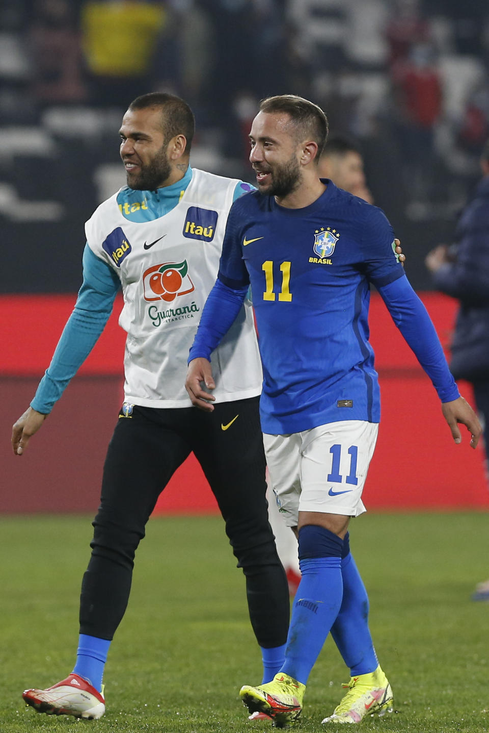 Brazil's Everton Ribeiro, right, and teammate Dani Alves celebrate their team's 1-0 victory over Chile during a qualifying soccer match for the FIFA World Cup Qatar 2022 at Monumental Stadium in Santiago, Chile, Thursday, Sept. 2, 2021. (Claudio Reyes/Pool via AP)