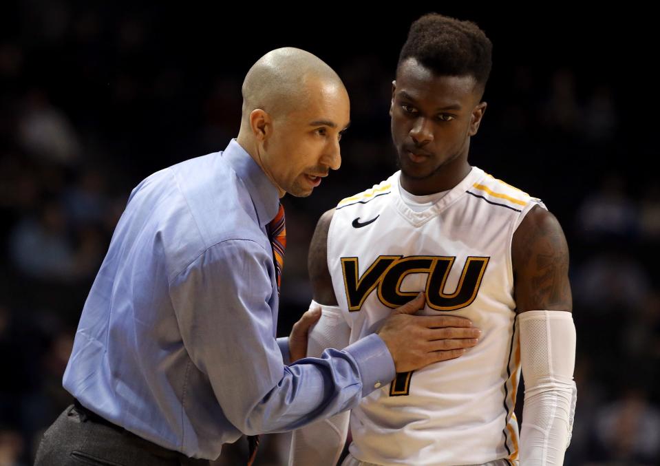 Head coach Shaka Smart of the Virginia Commonwealth Rams talks to JeQuan Lewis during the 2014 Atlantic 10 Men's Basketball Tournament  at Barclays Center on March 15, 2014.