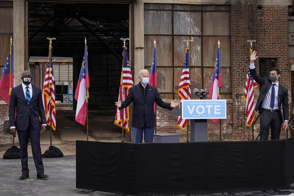 Flanked by U.S. Democratic Senate candidates Rev. Raphael Warnock (left) and Jon Ossoff (right), President-elect Joe Biden gestures to the crowd at the end of a drive-in rally at Pullman Yard on December 15, 2020 in Atlanta, Georgia. (Photo: Drew Angerer via Getty Images)