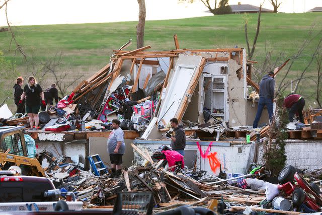 <p>Nikos Frazier/Omaha World-Herald via AP</p> Families sift through tornado damage near Omaha, Neb.