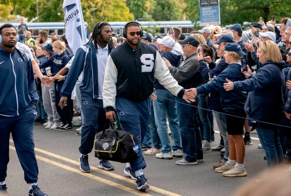 Penn State defensive tackle PJ Mustipher high fives fans as he and the team arrive at Beaver Stadium for the game on Saturday, Sept. 24, 2022.