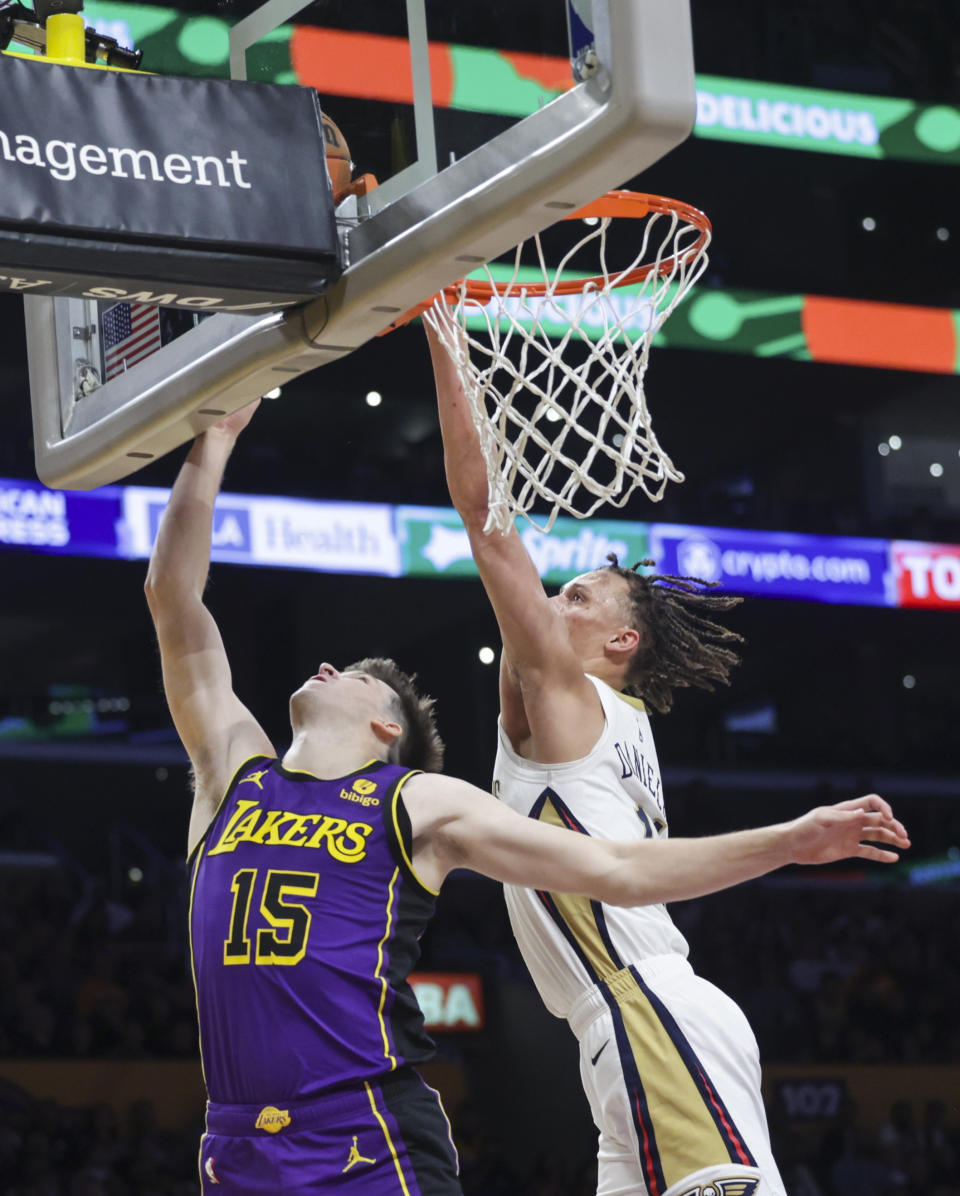 Los Angeles Lakers guard Austin Reaves (15) shoots as New Orleans Pelicans guard Dyson Daniels (11) defends during the second half of an NBA basketball game Friday, Feb. 9, 2024, in Los Angeles. (AP Photo/Yannick Peterhans)